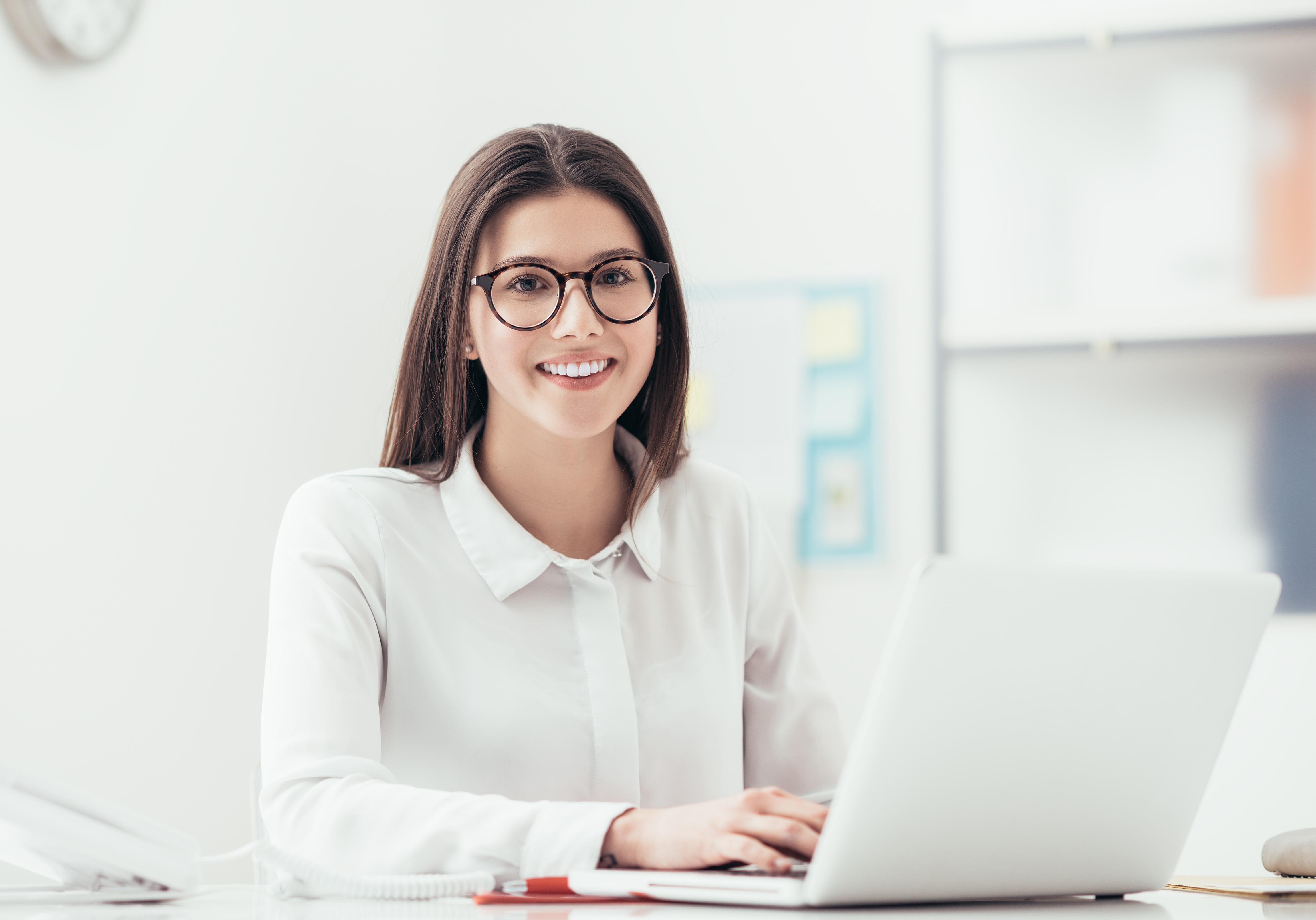 Female sitting at desk typing on a laptop computer