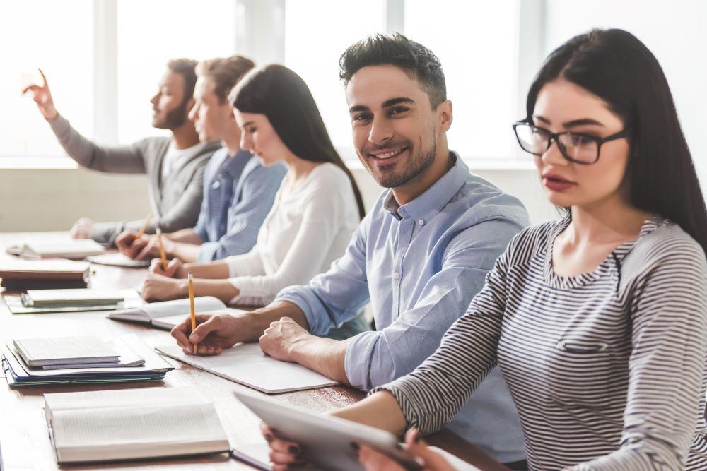 Row of students at desk male smiling
