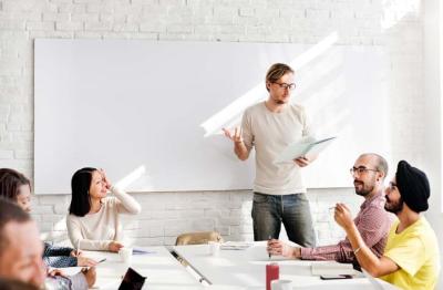 Students with teacher in classroom with whiteboard