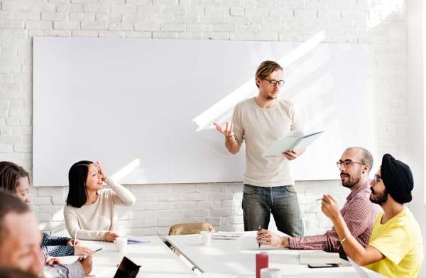 Students with teacher in classroom with whiteboard